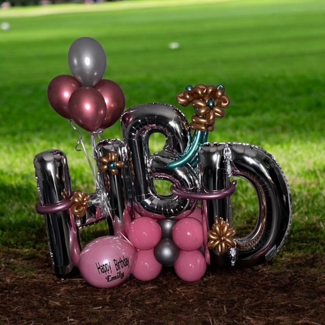 Letras gigantes HBD de globos plateados con globos rosas y nombre “Emily”