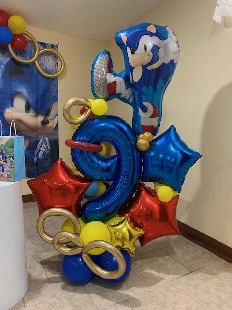 Torre de globos con número 9 azul, estrellas rojas y doradas y globo de personaje